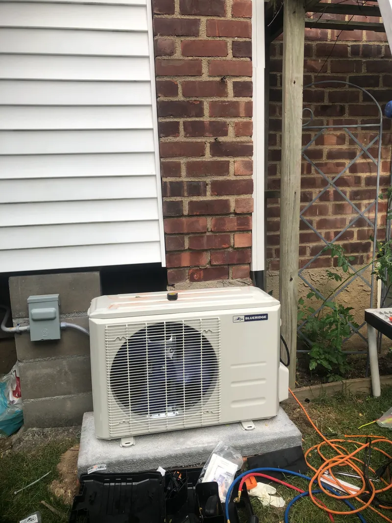 AC condenser against brick wall